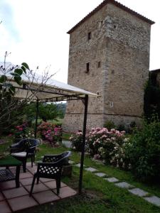 um pátio com cadeiras, uma mesa e um edifício em Castello di Casallia em Vetulonia