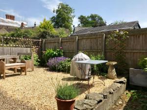 un jardin avec une clôture, une table et un banc dans l'établissement Number 22, Castle Street, à Hay-on-Wye