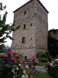 um grande edifício de pedra com flores em frente em Castello di Casallia em Vetulonia