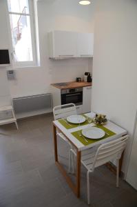 a kitchen with a table and two white chairs at Le Clos des Salins in Toulouse
