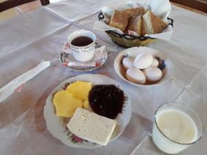 a table with plates of cheese and bread and a cup of coffee at Hotel Grabova in Grabova e Sipërme +67 photos