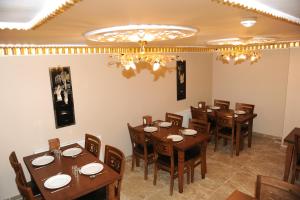 a restaurant with wooden tables and chairs and a chandelier at Hotel Umit 2 in Istanbul