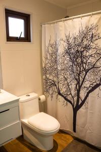 La salle de bains est pourvue d'un rideau de douche avec un arbre. dans l'établissement Casa Las Puyas Top Hill Incredible View + Hot Tub, à Navidad