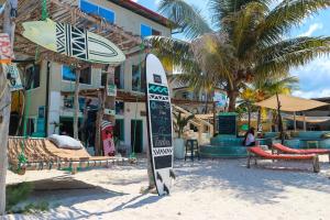 a surfboard in the sand in front of a resort at Ebb & Flow in Paje