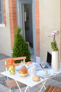 a white table with food and a laptop on it at Le Clos des Salins in Toulouse