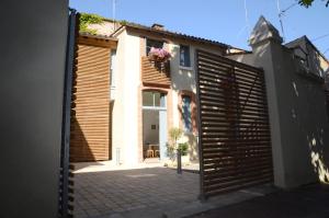a house with a wooden gate in front of it at Le Clos des Salins in Toulouse