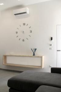 un orologio su un muro bianco con un divano di LOFT 92 a Margherita di Savoia