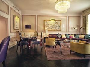 a living room with a couch and a table and chairs at Grand Hotel Europe, A Belmond Hotel, St Petersburg in Saint Petersburg