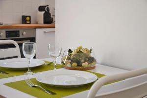 a table with plates and glasses and a bowl of fruit at Le Clos des Salins in Toulouse
