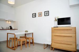 a kitchen with a table and a tv on a dresser at Le Clos des Salins in Toulouse