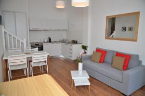 a living room with a couch and a table and a kitchen at Le Clos des Salins in Toulouse