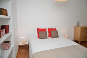 a bedroom with a white bed with red pillows at Le Clos des Salins in Toulouse