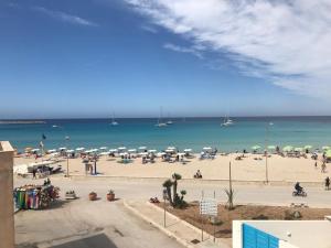 una playa con sombrillas y gente en la playa en Sul lungo mare posizione unica, en San Vito lo Capo