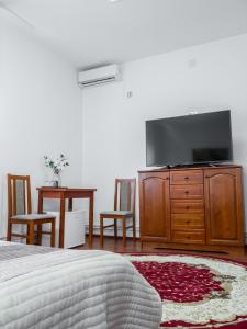 a bedroom with a bed and a tv and a table at Fabrik Haus in Marghita