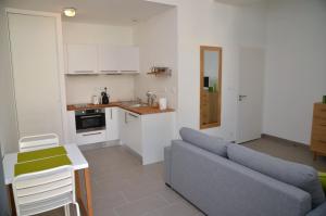 a living room with a couch and a kitchen at Le Clos des Salins in Toulouse