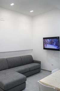 un soggiorno con divano e TV a parete di LOFT 92 a Margherita di Savoia
