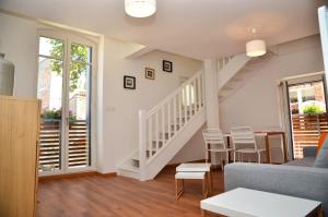 a living room with a staircase and a table and chairs at Le Clos des Salins in Toulouse