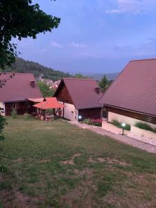 a group of buildings with red roofs and a yard at Guesthouse Stefanac in Otočac