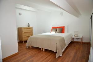 a white bedroom with a bed and a dresser at Le Clos des Salins in Toulouse