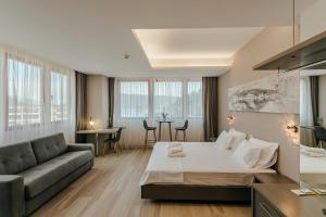 Habitación de hotel con cama grande y sofá en Centar Novi, en Herceg-Novi