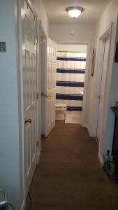 a hallway with a bathroom with a toilet and a door at Cabin by the lake in Burnside