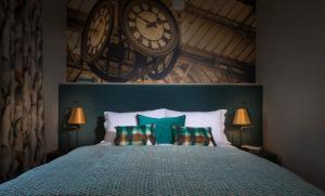 a bedroom with a bed with a large clock on the wall at Harper's Steakhouse with Rooms, Haslemere in Haslemere