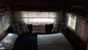 ein Sofa in einem Zimmer mit einem Fenster mit Kissen in der Unterkunft Sykovec Karavan Sýkorka in Nové Město na Moravě