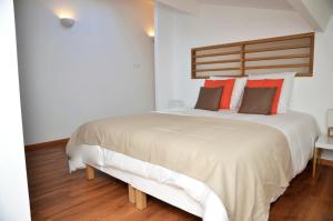 a bedroom with a large white bed with red pillows at Le Clos des Salins in Toulouse