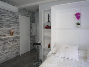 1 dormitorio con cama blanca y pared de ladrillo en IPANEMA Residence Le Minerve Studio, en Cannes
