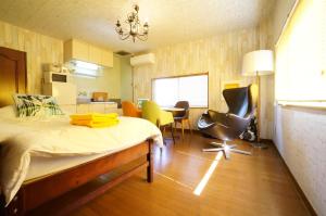 Zimmer mit einem Bett und Stühlen sowie einer Küche in der Unterkunft Tomato Takayama Station in Takayama