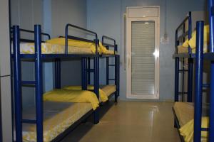 a room with three bunk beds with yellow sheets at Alberg Deltebre Xanascat in Deltebre +39 photos