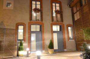 a facade of a building with windows and potted plants at Le Clos des Salins in Toulouse