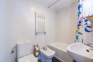 a white bathroom with a toilet and a sink at Balea 5 - Local Rentss in Orio +7 photos