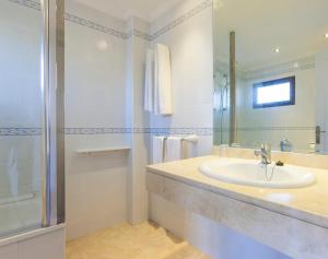 a bathroom with a shower, sink, and mirror at Globales Cortijo Blanco in Marbella
