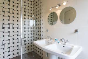 een badkamer met een wastafel en een spiegel bij Hôtel Restaurant Gastronomique La Huchette in Mâcon