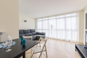 a living room with a table and a couch at Balea 5 - Local Rentss in Orio