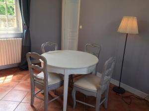 a white table with chairs and a lamp in a room at Gite de la petite masse in Amboise