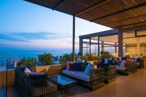 eine Terrasse mit Sofas und Tischen auf dem Dach in der Unterkunft I Resort Beach Hotel & Spa in Stalida