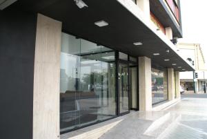 un bâtiment avec des fenêtres en verre sur le côté d'une rue dans l'établissement Booking 500, à Monterrey