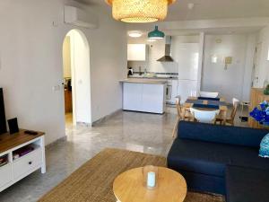 sala de estar con sofá azul y mesa en Bright apartment 300m from the beach en Sitio de Calahonda