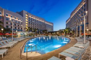 a large swimming pool with lounge chairs and buildings at Universal's Endless Summer Resort - Surfside Inn and Suites in Orlando