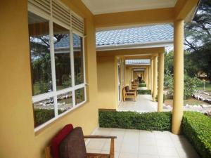 a yellow house with a porch with chairs and windows at Mt Moroto Hotel in Moroto