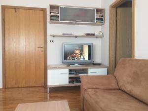 ein Wohnzimmer mit einem TV und einem Sofa in der Unterkunft Apartment Pavešić 1 in Mali Lošinj