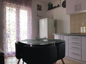 La cuisine est équipée d'une table, de chaises et d'un réfrigérateur. dans l'établissement Apartment Imela, à Pula