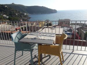 una mesa y sillas en un balcón con vistas al océano en B&B degli Aranci, en Palinuro