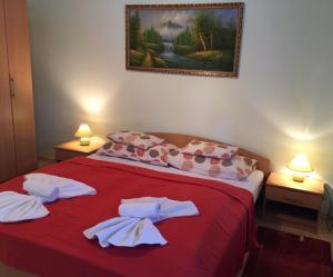 um quarto com uma cama vermelha e toalhas brancas em Green Park Apartment em Hévíz