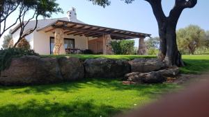 a house with a stone wall in a yard at Casa La Vela in Cala Liberotto