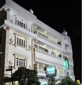 a large white building with a green traffic light at Hotel Savoy - Since 1951 in Jaipur
