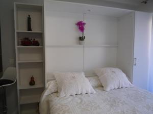 1 dormitorio con 1 cama blanca y 2 almohadas en IPANEMA Residence Le Minerve Studio, en Cannes