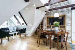 a dining room with a table and chairs and a brick wall at Elite Apartments Old Town Straganiarska in Gdańsk